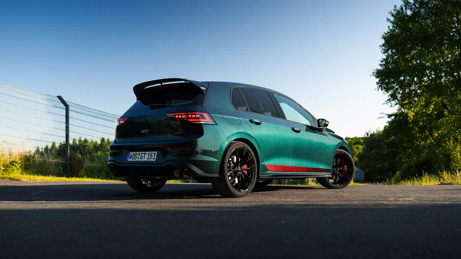 Heckansicht des VW Golf GTI Edition 50 in Dunkelgrün auf einer Strasse