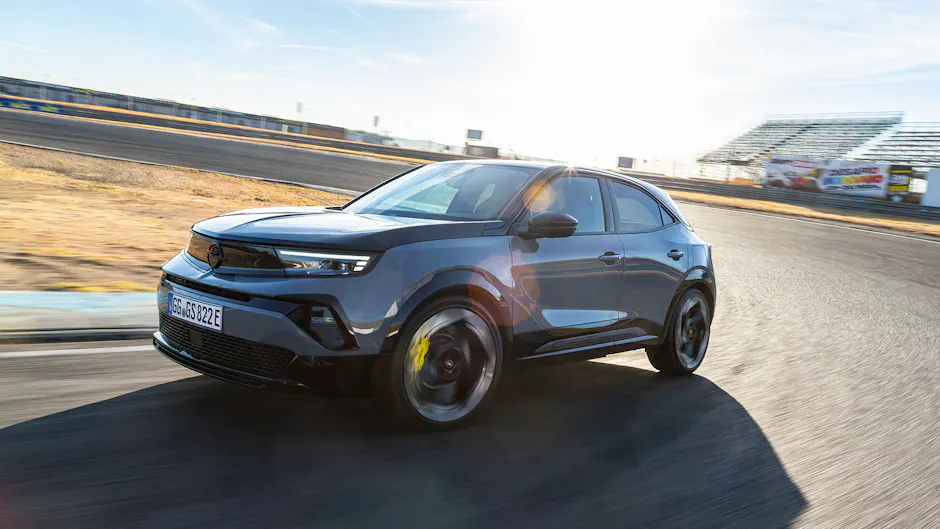 Opel Mokka GSE in dunkler Lackierung bei schneller Fahrt über die Rennstrecke