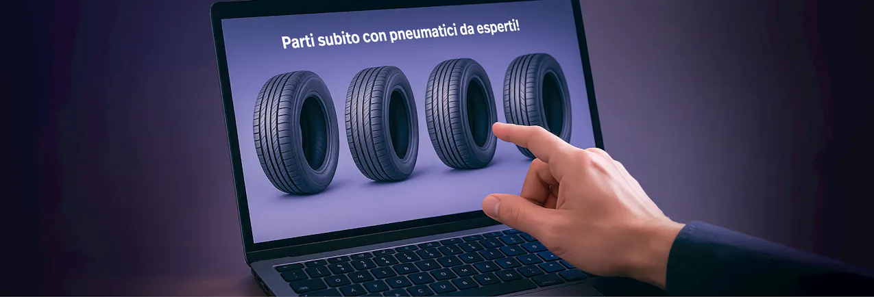 Computer portatile con il portale pneumatici Carmarket e quattro gomme visualizzate, utente che interagisce con il portale pneumatici online.
