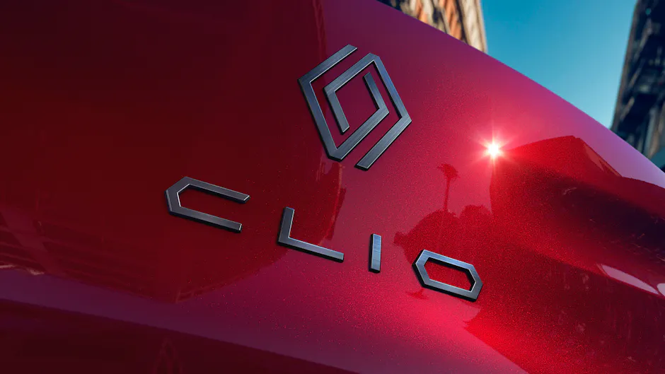 Renault Clio Schriftzug und Logo in Nahaufnahme auf roter Karosserie, modernes Markendesign.