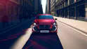Roter Renault Clio frontal in urbaner Strasse, dynamische Fahrt.