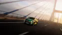 Grüner Renault Clio fährt über Brücke bei Sonnenlicht.