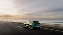 Grüner Renault Clio in Heckansicht auf offener Strasse.