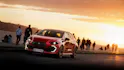 Roter Renault Clio bei Sonnenuntergang am Meer.