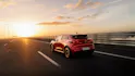 Roter Renault Clio in Heckansicht auf Autobahn bei Sonnenaufgang.