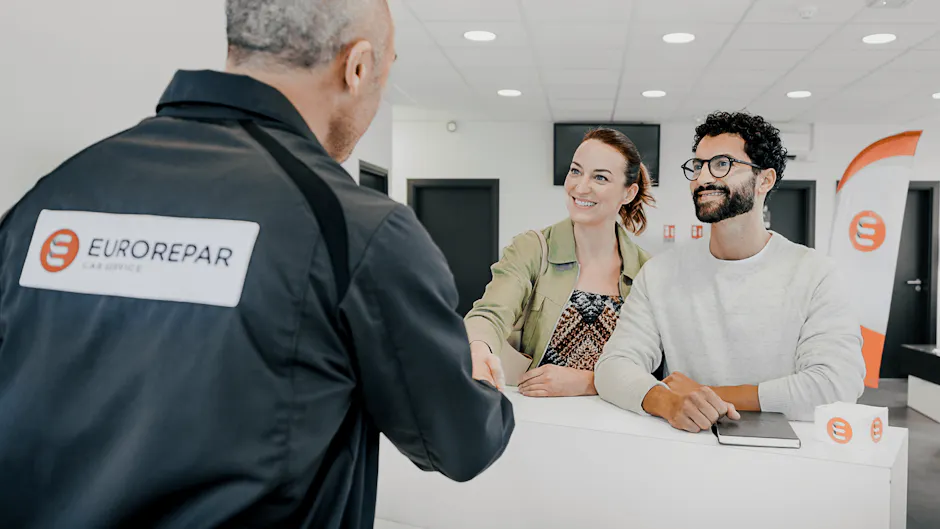 Un collaborateur d'Eurorepar aide deux clients.