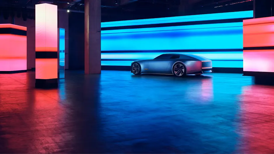 Jaguar Type 00 in blu, in una stanza illuminata, visto da dietro.
