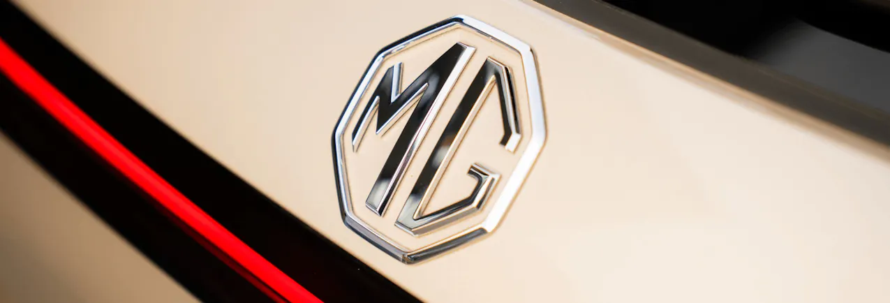 MG Logo in Silber auf dem beigen Auto