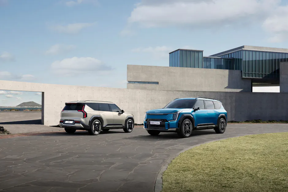 Kia EV9 en argent, Kia EV9 GT-Line en bleu, devant une maison moderne