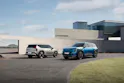 Kia EV9 en argent, Kia EV9 GT-Line en bleu, devant une maison moderne