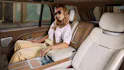 Range Rover SV Interieur, Frau sitzt auf dem Sitz und bedient ein Display