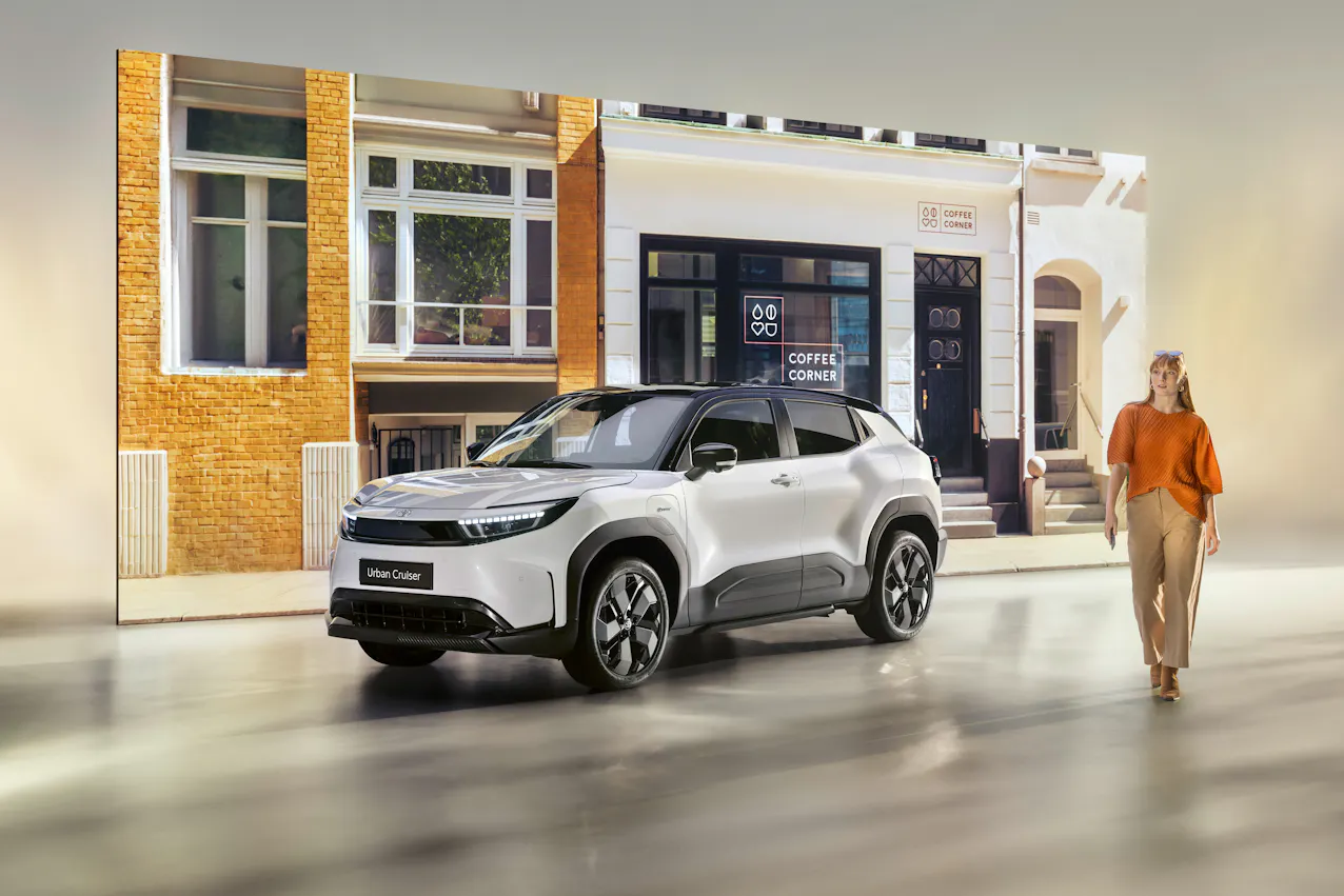 Toyota Urban Cruiser vu de face avec la femme à côté dans un environnement urbain
