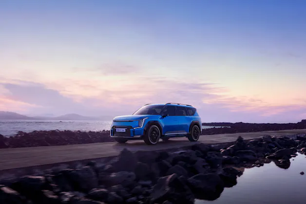 Kia EV9 GT-Line in Blau, während der Fahrt, das Meer im Hintergrund