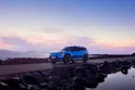 Kia EV9 GT-Line in Blau, während der Fahrt, das Meer im Hintergrund